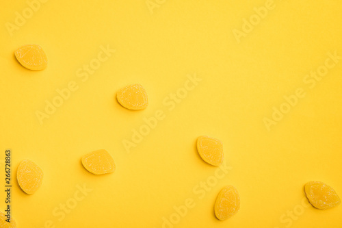 top view of delicious sugary jellies scattered on yellow background