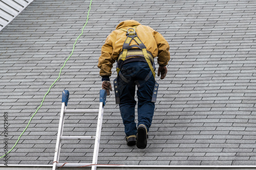 Wallpaper Mural House during day with gray color Single Family Home and construction man in yellow uniform walking on roof shingles and ladder during repair Torontodigital.ca