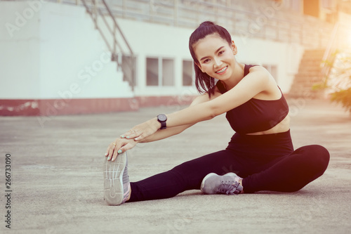 Health, sport and workout concept - Young Asian woman warm up body before jogging and workout daily. Female runner does stretching body to warm up before exercise.