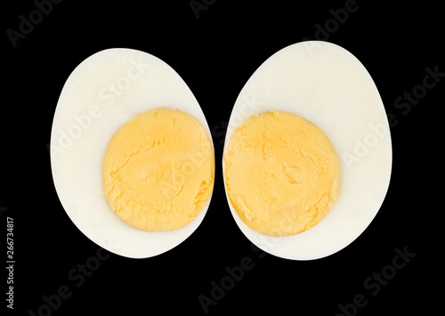 Boiled egg sliced two piece isolated on black background on top view