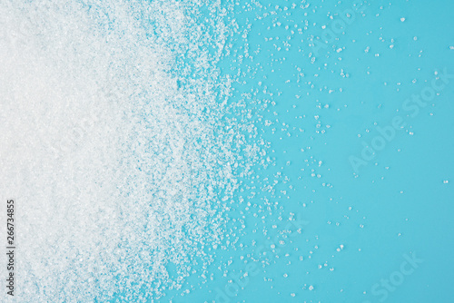 White sugar splash on blue background texture top view