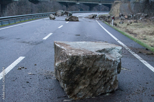 rockfall on the mainroad in dolomites area, northern Italy.  Big boalder on the road. danger zone photo