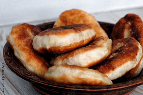 Photography Potato pies on a ceramic dish opposite light background
