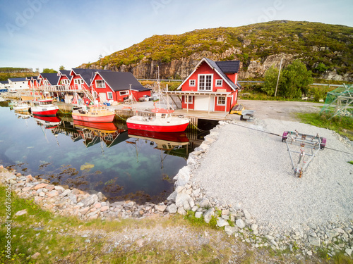 Norwegian traditional red houses over the water in the bay photo