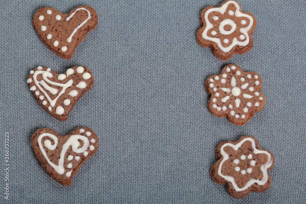 Gingerbread cookies decorated with a pattern of white glaze. On a background of gray fabric. Gingerbread cookies decorated with a pattern of white glaze. On a background of gray fabric.