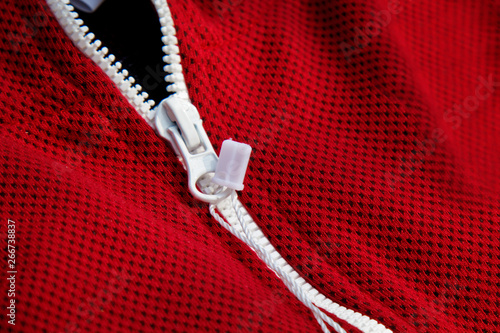 red sportswear closeup top view. white zip line. breathable knitwear. clothing details macro