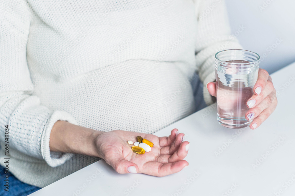 Conceptual photo of pregnancy healthcare. Pregnant woman taking pills during pregnancy. Last months of pregnancy Conceptual photo of pregnancy healthcare. Pregnant woman taking pills during pregnancy. Last months of pregnancy