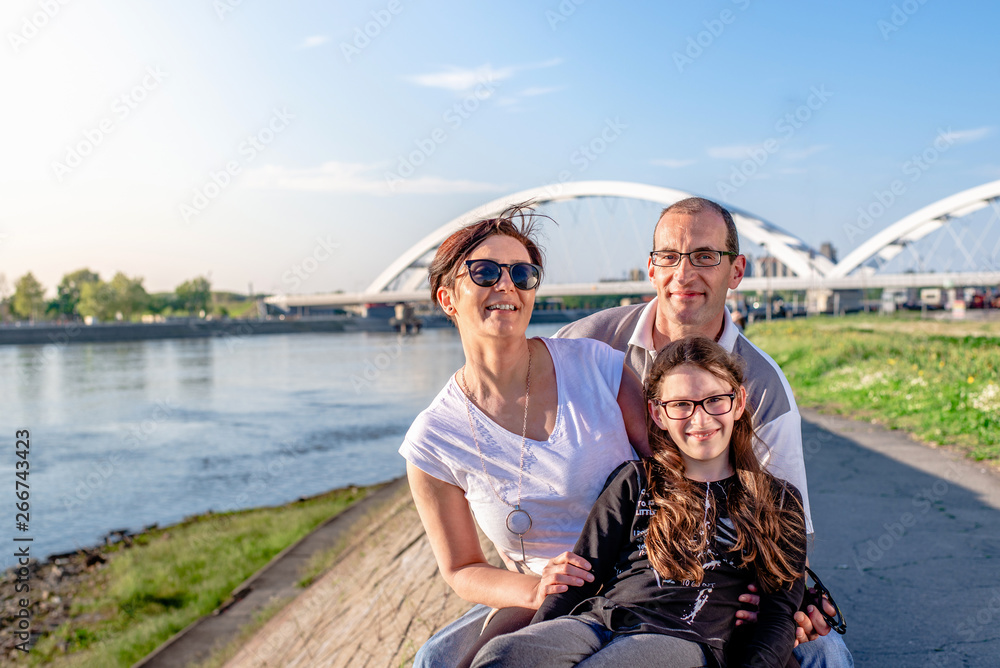 Happy caucasian family of three together in the river quay