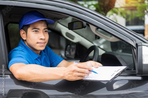 Delivery man checking document list on clipboard outdoor and Cardboard Boxes, Package delivery concept.