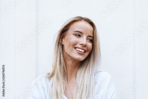 Close up of a smiling young blonde woman standing