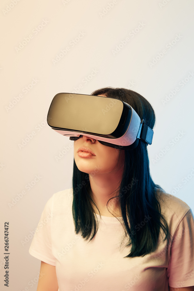 attractive brunette girl wearing virtual reality headset on beige and blue attractive brunette girl wearing virtual reality headset on beige and blue