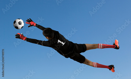 Soccer goalkeeper on sky background photo