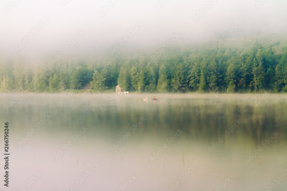 Φωτογραφία Canoe moves across misty morning lake