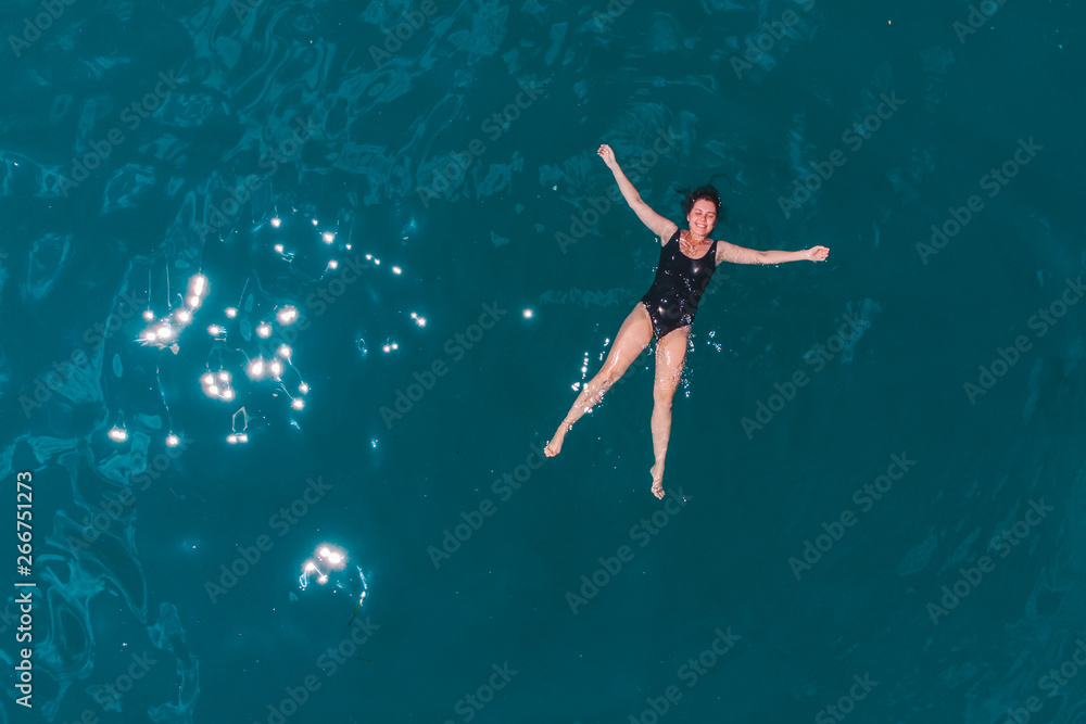 young woman swimming in blue azure water young woman swimming in blue azure water