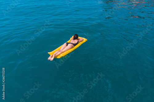young woman swimming in blue azure water