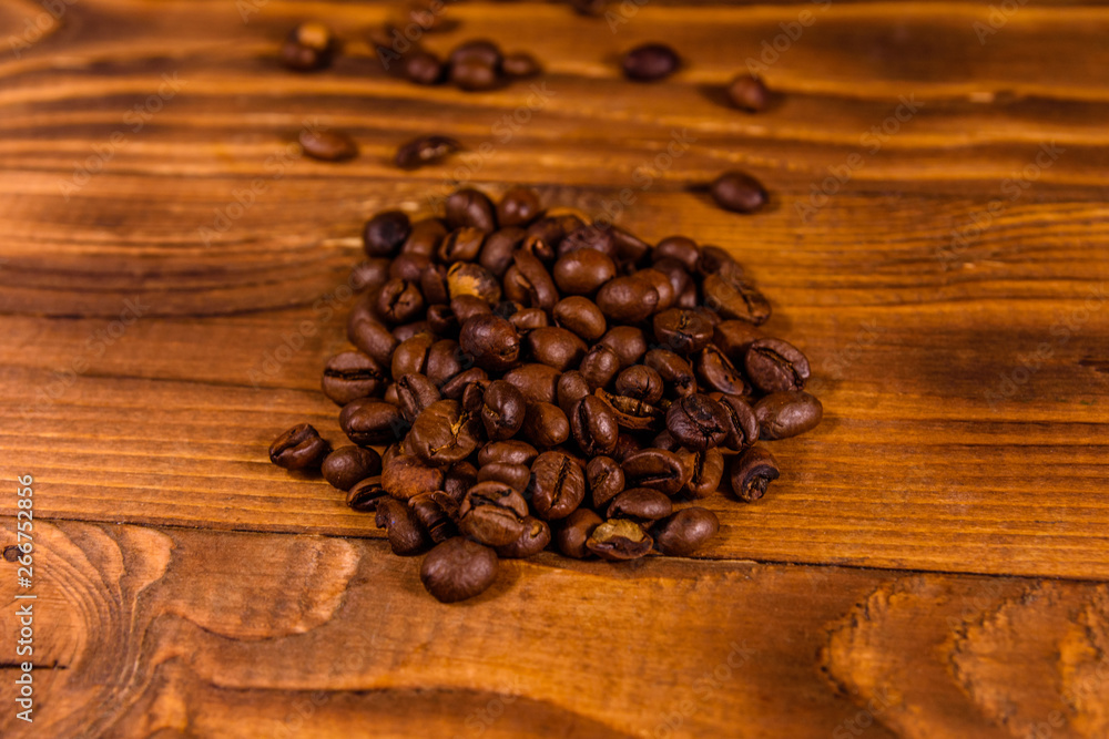 Pile of the coffee beans on wooden table Pile of the coffee beans on wooden table