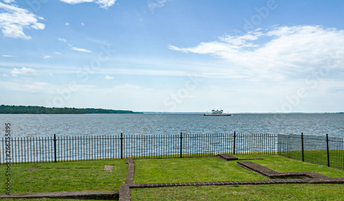 A ferry crosses a body of water on a sunny spring day.