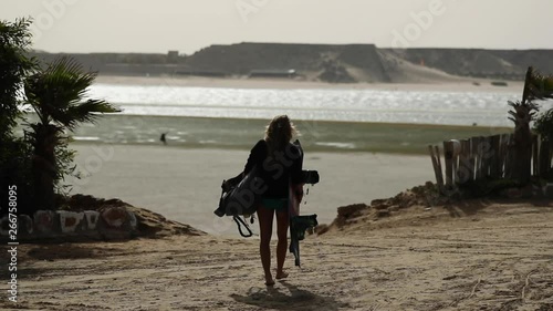 Woman Walking With Kiteboarding Equipment on Beach