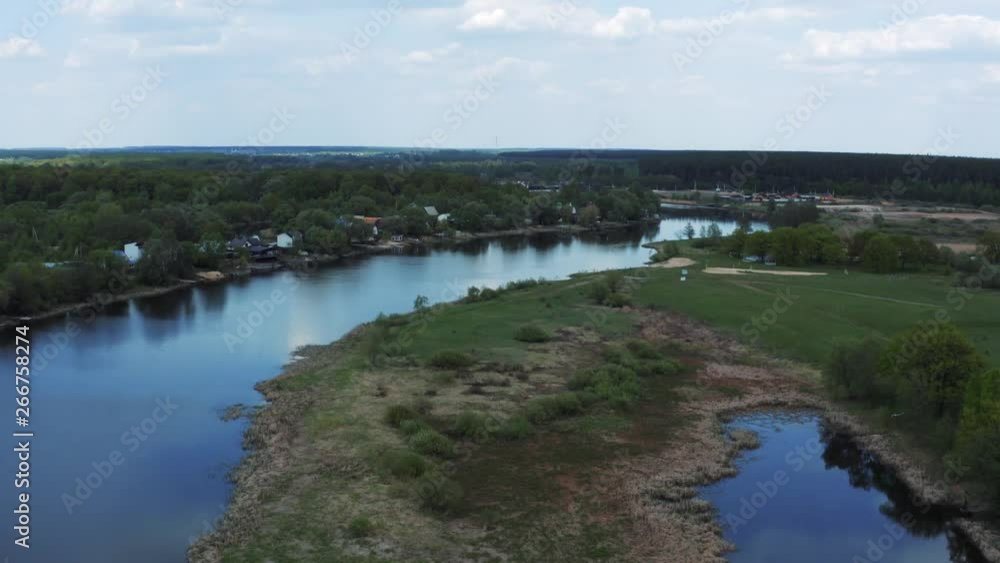 Aerial view of river with reflected blue sky and clouds, green meadows with trees and plants. Beautiful summer nature landscape from above Aerial view of river with reflected blue sky and clouds, green meadows with trees and plants. Beautiful summer nature landscape from above