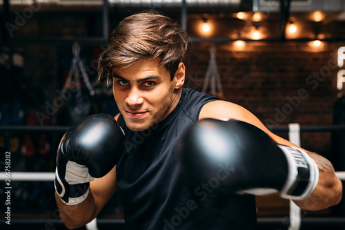 Close up of a young male boxer with boxing gloves punching towards camera © Artem Varnitsin