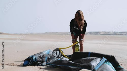 Young Woman Pumping Air into Kite