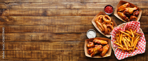 Print op canvas pub appetizers such as chicken wings, onion rings and french fries in panoramic