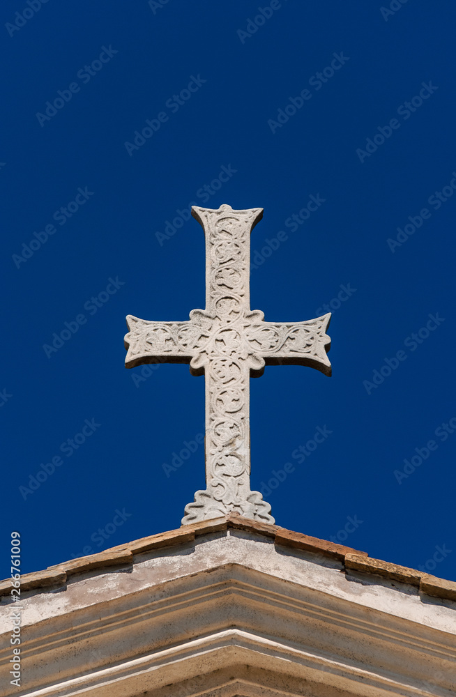 Ancient Holy cross with relief against blue sky