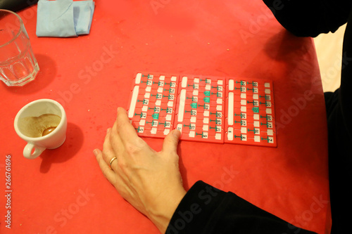 woman who paying bingo with a cup of cofee on the table photo