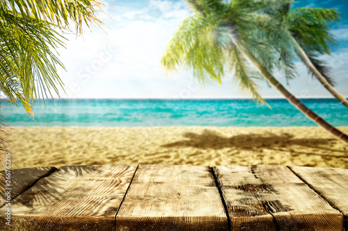 Summer landscape of beach ocean and palms. Wooden old table of free space for your decoration. 