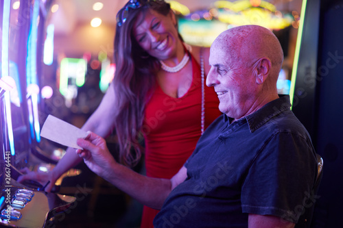 Canvas Print happy mature couple with payout ticket at casino