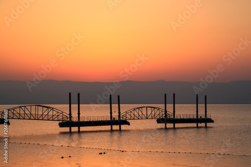 Silhouette of female tourist watching the sunrise over the Sea of Galilee