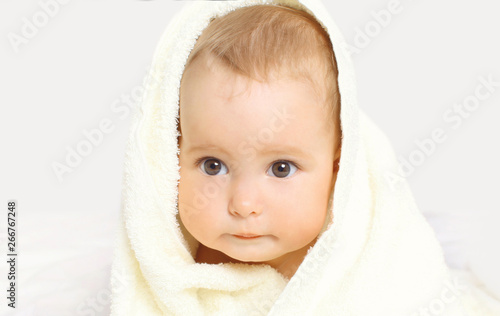 Portrait close-up face cute baby under towel on background