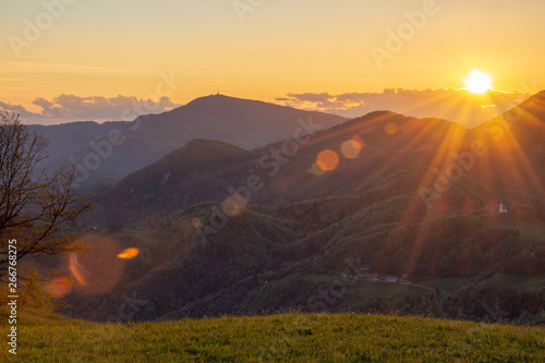 Sunset over the Slovenian landscape. With hills and valley in the middle. Horizontal photo from hill Lisca, Slovenia, Europe. With beautiful sun rays. photo