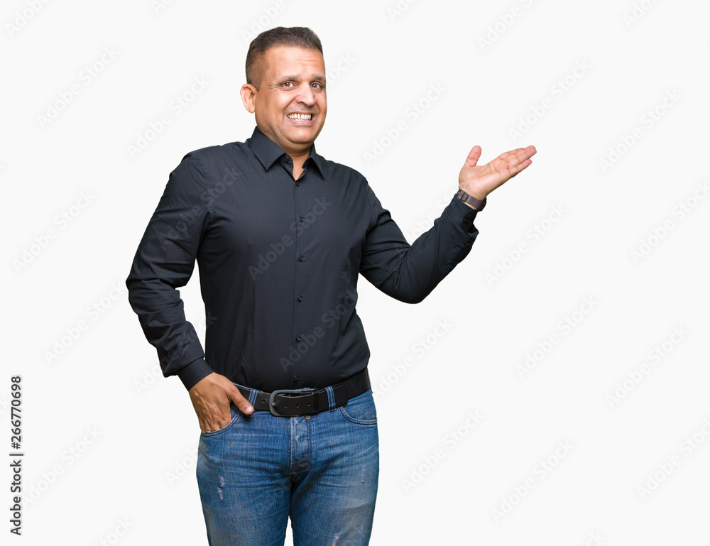 Handsome middle age arab business man over isolated background smiling cheerful presenting and pointing with palm of hand looking at the camera. Handsome middle age arab business man over isolated background smiling cheerful presenting and pointing with palm of hand looking at the camera.