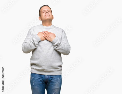 Middle age arab man wearing sport sweatshirt over isolated background smiling with hands on chest with closed eyes and grateful gesture on face. Health concept.