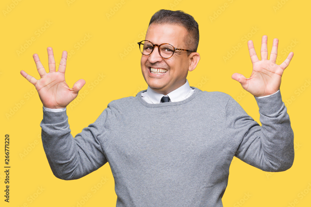 Middle age bussines arab man wearing glasses over isolated background showing and pointing up with fingers number ten while smiling confident and happy. Middle age bussines arab man wearing glasses over isolated background showing and pointing up with fingers number ten while smiling confident and happy.