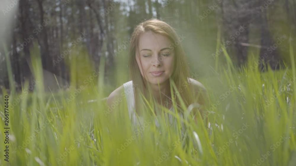 Beautiful woman in the green grass around spectacular forest Beautiful woman in the green grass around spectacular forest