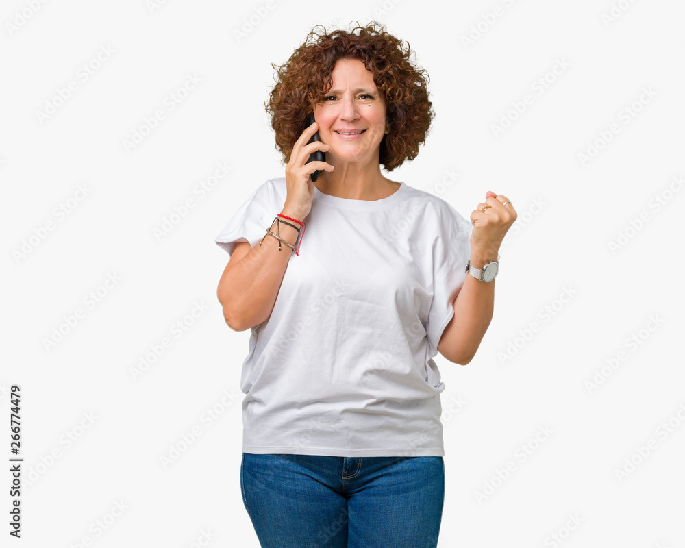 Middle ager senior woman talking on smartphone over isolated background screaming proud and celebrating victory and success very excited, cheering emotion Middle ager senior woman talking on smartphone over isolated background screaming proud and celebrating victory and success very excited, cheering emotion