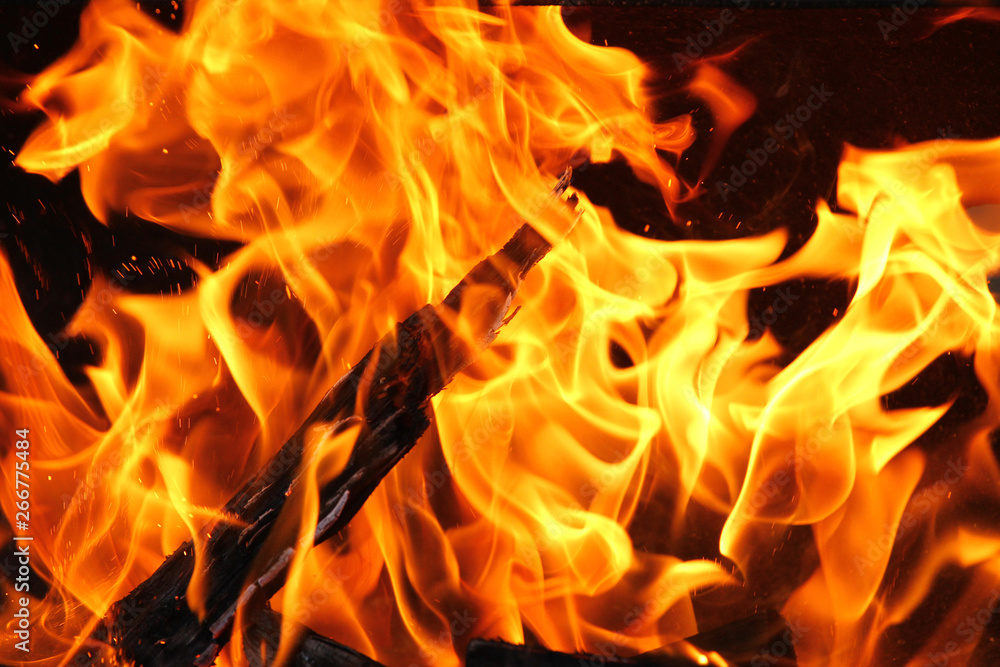 A shot of burning firewood in the fireplace. Close-up. Burning wood for a barbecue. Smoke and sparks. Fire background. A shot of burning firewood in the fireplace. Close-up. Burning wood for a barbecue. Smoke and sparks. Fire background.