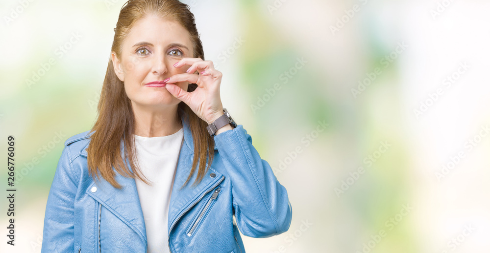 Beautiful middle age mature woman wearing fashion leather jacket over isolated background mouth and lips shut as zip with fingers. Secret and silent, taboo talking Beautiful middle age mature woman wearing fashion leather jacket over isolated background mouth and lips shut as zip with fingers. Secret and silent, taboo talking