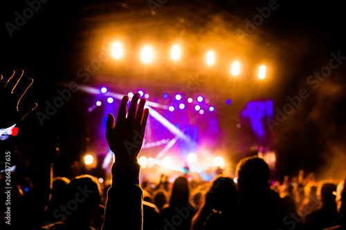 Fototapeta Naklejka Na Ścianę i Meble -  Picture of a lot of people enjoying night perfomance, large unrecognizable crowd dancing with raised up hands and mobile phones on concert. nightlife
