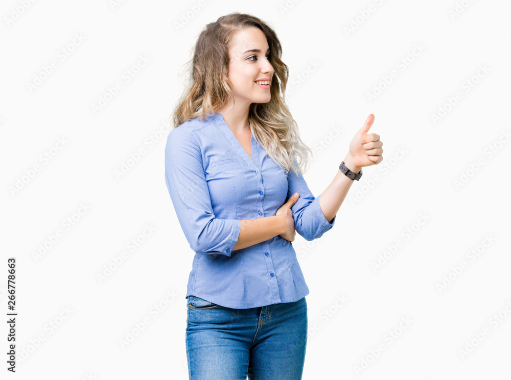 Beautiful young blonde business woman over isolated background Looking proud, smiling doing thumbs up gesture to the side Beautiful young blonde business woman over isolated background Looking proud, smiling doing thumbs up gesture to the side