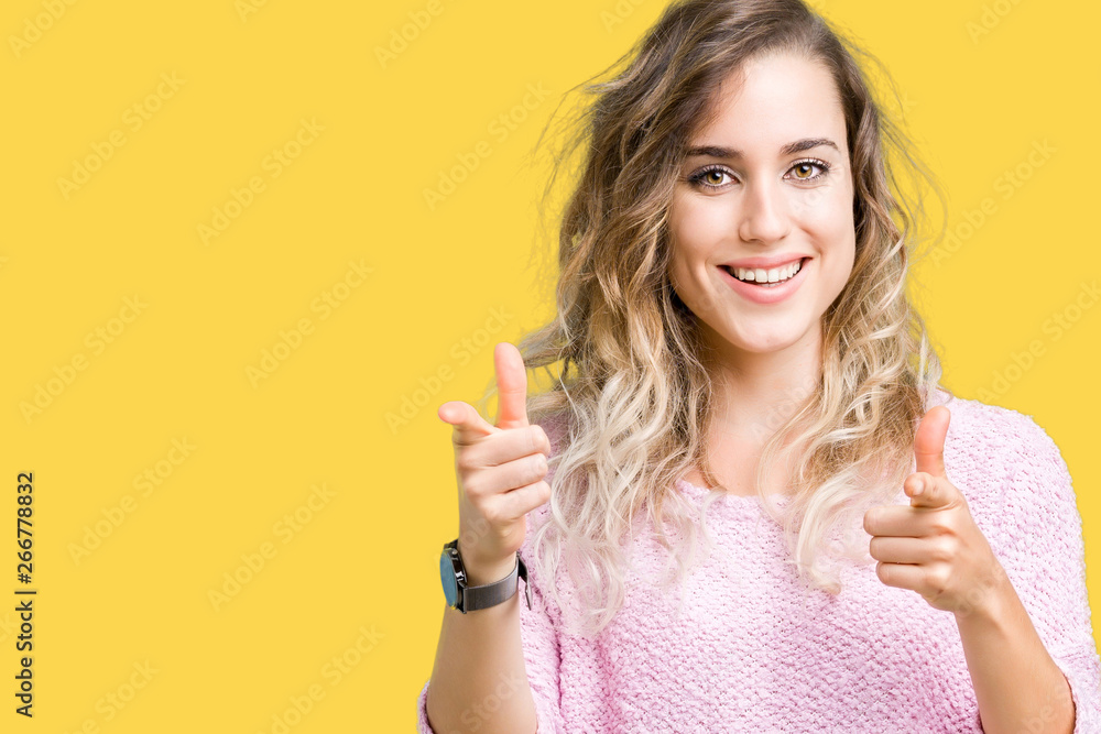 Beautiful young blonde woman over isolated background pointing fingers to camera with happy and funny face. Good energy and vibes. Beautiful young blonde woman over isolated background pointing fingers to camera with happy and funny face. Good energy and vibes.