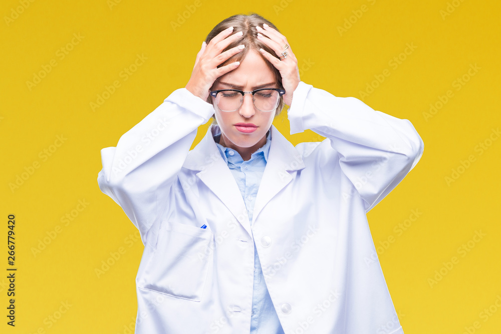 Beautiful young blonde doctor woman wearing white coat over isolated background suffering from headache desperate and stressed because pain and migraine. Hands on head. Beautiful young blonde doctor woman wearing white coat over isolated background suffering from headache desperate and stressed because pain and migraine. Hands on head.
