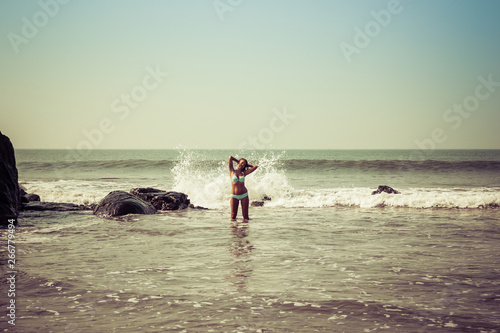 Portrait of a young woman on the background of waves and stones
