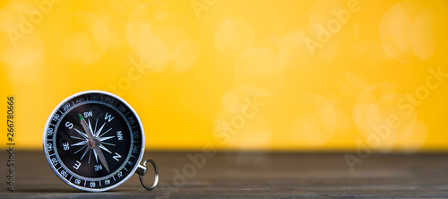 Old compass on an yellow background. Copy space for text or design