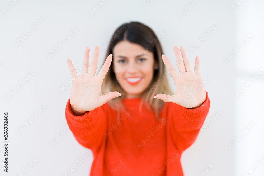 Young woman wearing casual red sweater over isolated background showing and pointing up with fingers number ten while smiling confident and happy. Young woman wearing casual red sweater over isolated background showing and pointing up with fingers number ten while smiling confident and happy.