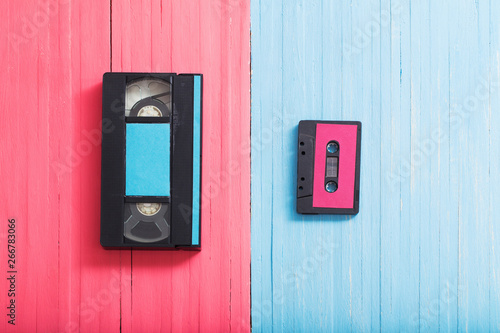 Video cassette and tape cassette on pink and blue wooden backgro © Maya Kruchancova