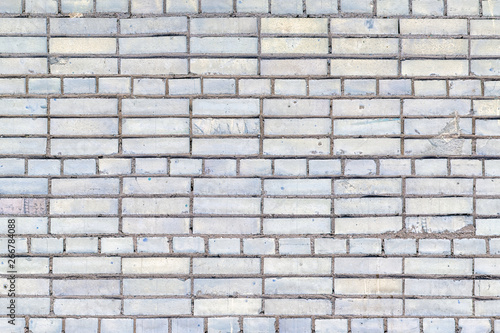 Wall of small bricks. Empty gray background with place for text. Neat brickwork with texture.