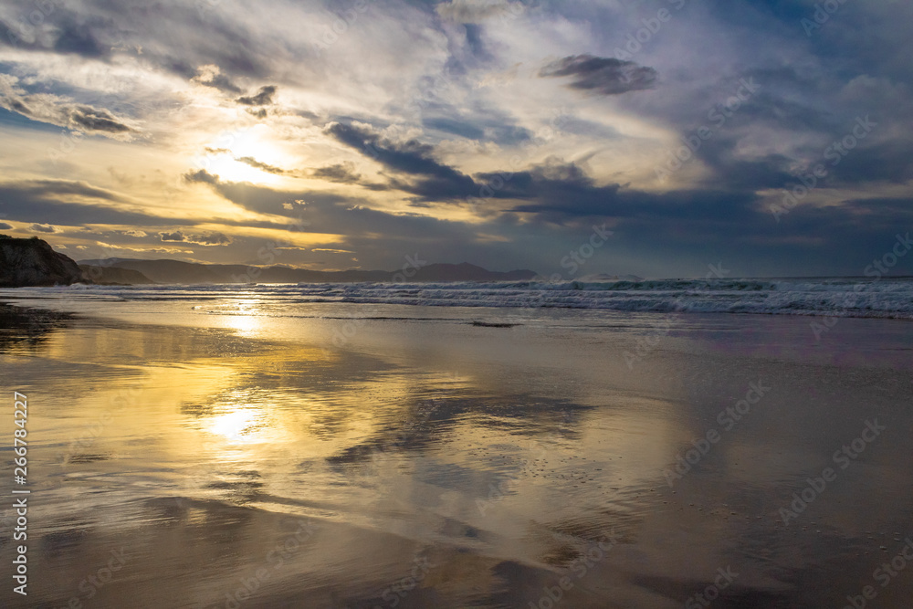 sunset on the beach of Atxabiribil, Sopelana, vizcaya. The sun is reflected on the seashore